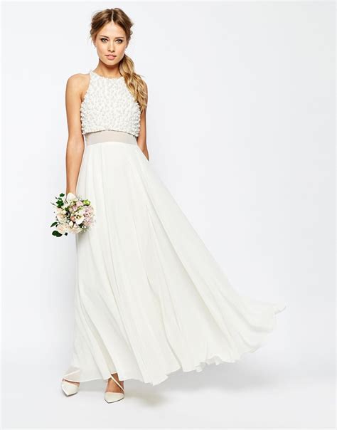 Asos bridal. ASOS DESIGN Lisa drape sleeve plunge wedding dress with floral embellishment in ivory. $289.00. ASOS DESIGN Mila floral embellished mesh wedding dress with tie straps in ivory. $309.00. Y.A.S Bridal tailored lace bridal mini dress in white. $216.00. Pieces Bride To Be sheer puff sleeve mini smock dress with 3D flowers in white. $126.00. 