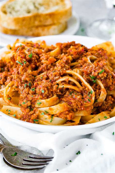 Authentic italian bolognese recipe. Add 2 tins plum tomatoes, the finely chopped leaves from ¾ small pack basil, 1 tsp dried oregano, 2 bay leaves, 2 tbsp tomato purée, 1 beef stock cube, 1 deseeded and finely chopped red chilli (if using), 125ml red wine and 6 halved cherry tomatoes. 