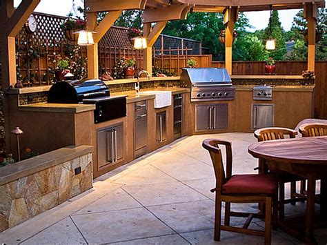 Backyard kitchen. Outdoor Kitchen Cabinets With Blue Marble Backsplash And Countertop. Modern orange cabinetry in slab door style, made of wood with a natural finish. Mid-sized traditional backyard concrete paver patio kitchen idea in with a wood gazebo, cast stone floor, blue backsplash, marble backsplash, blue countertop, marble countertop, available wood ... 