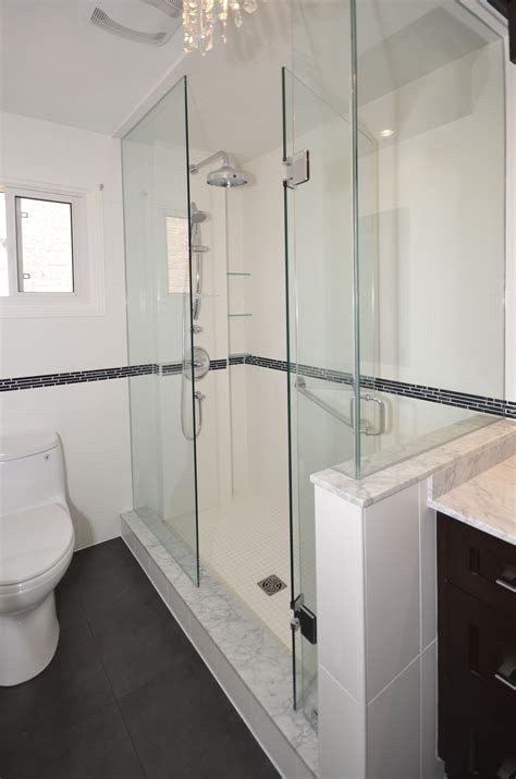 The knee wall in the shower is separated from the vanity with a glass wall--this prevents the space from feeling smaller and closed in. Bathroom - bathroom idea in Philadelphia Find the right local pro for your project. 