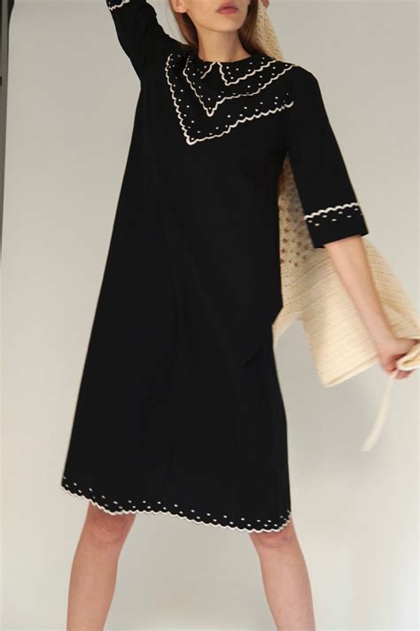 Batsheva dress. Long-sleeve midi dress in archival Laura Ashley Tea Rose print with elastic ruffled shawl collar that can be pulled down below the shoulders. Contrasting black cotton tie at waist and tiered bottom hem lined in eyelet lace. Pockets. Side zipper. Akdeniz wearing a size 2 is 5'9.5". Fits true to size. Delicate cycle or gentle wash. 