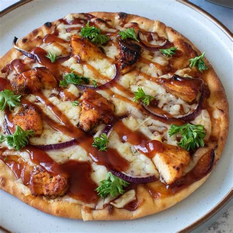 Bbq chicken flatbread. Preheat oven to 450°F. Place flatbread on sheet pan. Spread BBQ sauce on flatbread, sprinkle with cheese, top with chicken and pickled onions. Bake 8-10 minutes or until cheese is melted and crust is crisp on the bottom. Drizzle flatbread with Ranch dressing and garnish with cilantro. 