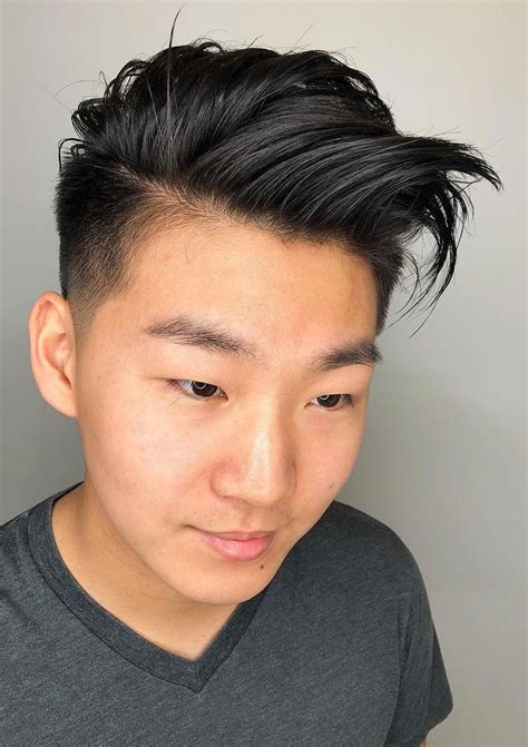 Common Asian hairstyles derive from Japanese Samurai warriors, the "Man Bun.". They come in various styles: The loose man bun, the man bun undercut, and the half up man bun. Also, two block cut is the most widespread haircut in Korea and K-Pop culture. The faux hawk, neat side part, and brow out styles are also popular, mostly by younger men.