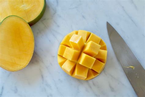 Best way to cut a mango. 1. Make sure stem is on top, then cut vertically, ¼ inch away from the midline. 2. Make the same cut on the other side. 3. Cut the flesh in a grid like pattern without going through the mango skin. 4. Use a large spoon to detach the flesh from the skin and scoop the cubes out. Here's a handy step-by-step flyer. 