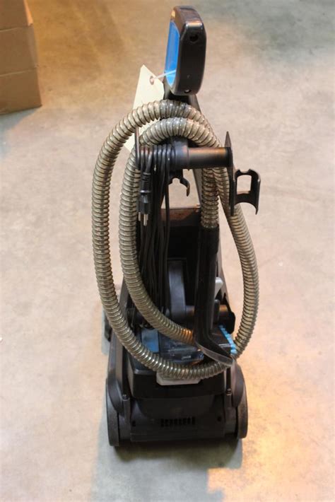 Plug the power cord into a nearby outlet, then locate the buttons on the cleaner's back. Press both buttons down to turn the machine on and activate its heating system. 2. Pull the handle's trigger while moving the cleaner forward and back. Pull the trigger to spray water onto the carpet.. 