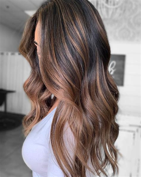 Caramel Ombre Highlights. This is another take on the Tiger's Eye trend, but with a slightly more ombre approach. The ends are lightened to a golden caramel color, and lowlights are created with a dark, reddish-brown. The highlights don't go all the way up to the roots of the hair, creating the classic ombre look.. 