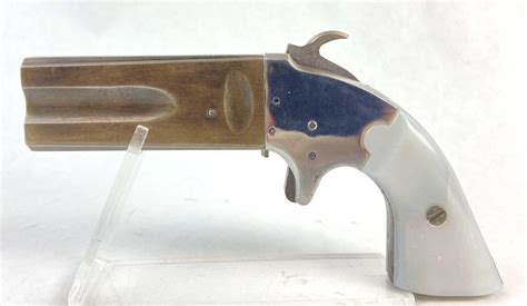 Black powder derringer. PH1260 VEST POCKET DERRINGER. Grips are 2 piece – white simulated ivory (polymer). Brass frame. Barrel is .31 caliber, brass, 2 3/8” length. Round - .625 od. Smoothbore. .310 diameter. Front sight is brass bead. Ignition is percussion - #11 cap. Single shot. 