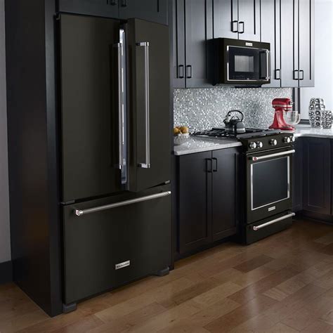 Black stainless steel. The black hardware adds a touch of contrast and sophistication, and the stainless steel appliances bring a modern and sleek look to the space. The light wood floors provide a warm contrast to the cool-toned cabinets and countertops and add a touch of natural beauty to the kitchen. Photo by Loop Interior Design Inc. 