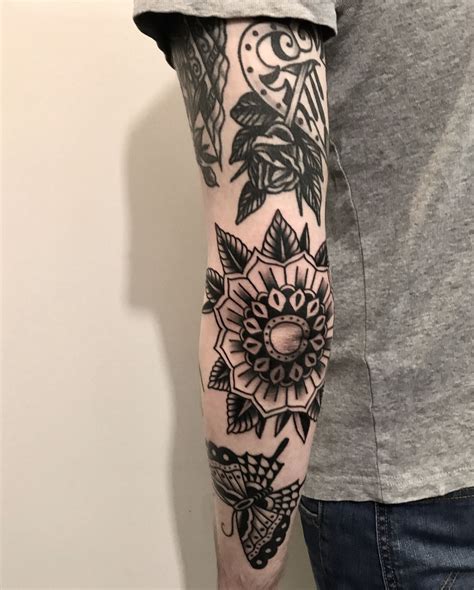 Black traditional elbow tattoo. This black-and-white idea is the epitome of a traditional octopus tattoo. It features a clear view of the creature’s eyes and head and places a dramatic emphasis on its tentacles. It has accurate shading and uses white space to create contrast throughout the drawing. 