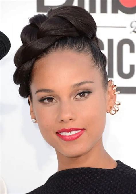 Part your hair down the middle, then slick your hair back into two high ponytails on each side. Wrap the base of the ponytail with a strand of hair, then use styling gel and a toothbrush to lay your edges down. Finally, use a few gems to spice up the style. 7. Low, curly ponytail.. 