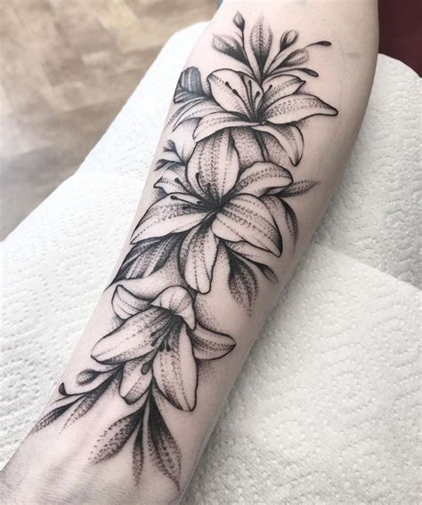 Black white lily tattoos. Discover a stunning black and white Lily flower tattoo design on a white background. Perfect for those who appreciate timeless elegance. Save this Pin for your next tattoo inspiration! 