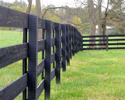 Black wood fence. Fences appear decorative or utilitarian depending on the materials used to construct the fences. Fencing materials vary in their costs, looks, durability, maintenance needs and sec... 