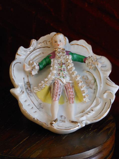 BEAUTIFUL BONE CHINA LACE FIGURINE-8 TALL BY 7 LONG, LADY IS MISSING HER RIGHT HAND, WHICH IS NOT NOTICIBLE AT ALL. THIS FIGURINE IS MARKED BONE CHINA LACE AT THE BOTTOM. HAS ORIGINAL STICKER ON IT. 