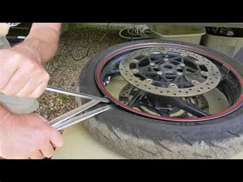 Here's an effortless way to break a motorcycle tire bead. I did this on the rear tire of my DRZ400SM. Use a bench vise and a block of wood to protect the rim.... 