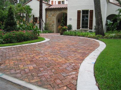 Brick paver driveway. Step 2. Investing in a paved driveway is a smart way of preventing slips and falls, providing additional parking for family and friends, and improving curb appeal. Make sure you do your best to manipulate the gradient so that water will flow away from your garage and house. Then, compact the area using a plate compactor. 