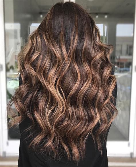 16. Warm Caramel Highlights on Dark Brown Hair. This dark brown mane is slightly misted with auburn just to elicit a red sparkle in the sunlight, but the main focus is placed on the face by framing it with the softest caramel. By mane_ivy. 17. Subtle Brown Highlights on Medium Hair.. 