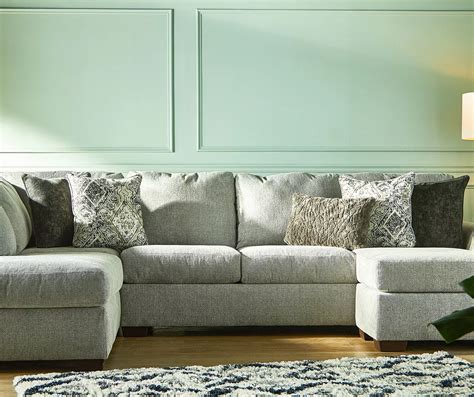 The soft chenille upholstery fabric in a light gray color tone is accented with a mix of patterns and textures on the five toss pillows. Designed with sleek lines and contemporary flared arms, the Parkdale dual chaise sectional will add style and comfort to any family room or living area in your home.. 