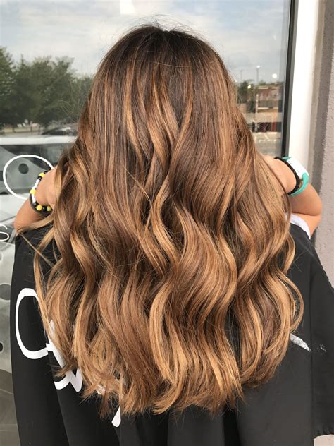 10. Golden Brown Ombre. Long hair works great to show off a transition from dark brown to a medium golden brown hair color. This ombre-balayage blend is simply stunning paired with soft curls and long layers. Plus, the color maintenance is easy! Instagram / @kelsforbeauty.. 