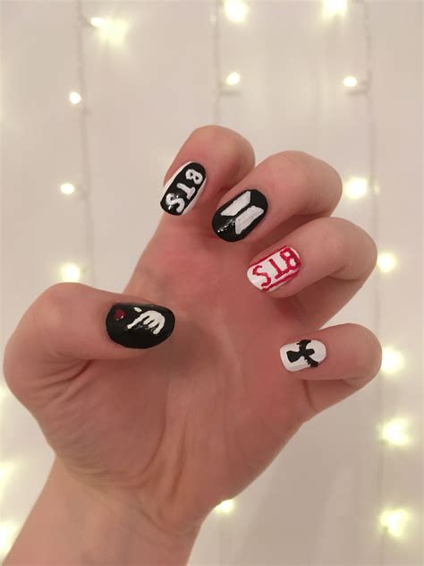 Here are some nail art designs inspired by BTS that you can try out yourself! Wings. The first design is inspired by BTS’s album cover for “Wings”. It features a simple yet elegant black and white color scheme with a pop of red in the form of the band’s logo. To create this look, start with a base coat of white polish.. 