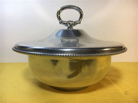 A beautiful Buenilum Aluminum Bowl with Twisted Handles. This Buenilum Aluminum Bowl was produced by Frederick Buehner-Wanner Company of Connecticut between 1933 and 1969. The Aluminum Bowl measures 11 inches in diameter without handles, 13 inches with handles and it is 3 3/8 inches deep. The bottom is marked with the Buenilum Handwrought mark. 