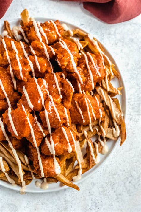 Buffalo chicken fries. Spread fries on baking sheet and bake until about 10 minutes are left on the baking time. Pull fries out of oven and top with cheese and diced buffalo chicken. Finish baking until fries are done, cheese is melted, and chicken is warm. Top with ranch, green onions, and bleu cheese rumbles. Serve warm. 