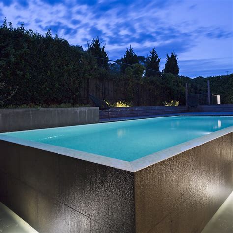 Building a pool. Add any plumbing and electrics such as lighting, filtration, heating and circulation. Cover the sides and base of the hole with concrete and allow it to cure. Add a layer of waterproof coating to the concrete. Lay tiles covering the walls and floor of the concrete base to create a smooth surface for swimming. 