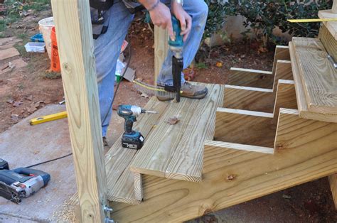 Building deck stairs with a landing. Simply rest the cascading box stair frames on the slab. You can secure the lower frame to the concrete if you wish and elevate it slightly with washers to keep it from rotting over time. Do not connect the upper box stair to deck. Set it off the fascia about 1/4" to allow for any minor annual vertical movement. 