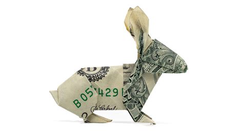 Bunny dollar bill origami. Fold both the top left and top right corners down to the bottom point and crease well. Start with a crisp dollar bill. Make Your Origami Money Bunnys Ears. Fold in half along one of the diagonals. Both start with a water bomb base and both are cute. Your Dollar Origami Bunny Is Complete. 