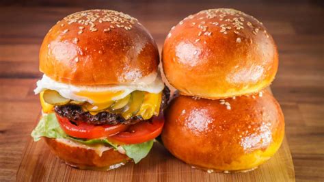 Buns burgers. Remove the dough to a lightly oiled surface and knead until it is smooth and elastic. Place the dough ball in a greased bowl, cover with plastic wrap, and allow to rise until doubled in bulk, about 1 hour. Form the rolls and bake the buns: Line a baking sheet with parchment paper. Preheat the oven to 375 degrees. 