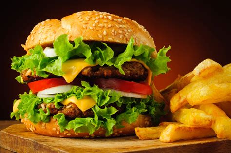 Burger and fries. Burger and fries on wooden board on dark stone background Burger and fries on wooden board on dark stone background. Homemade burger or cheeseburger, french fries and ketchup. Tasty sandwich. Top view with copy space for text burger and fries stock pictures, royalty-free photos & images 