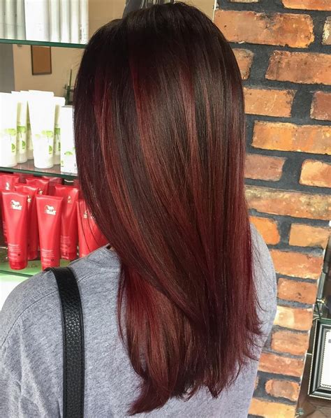 The burgundy hair color paired with caramel highlights adds a touch of warmth and style. Discover the latest hair trends and get inspired to try something new. Get the perfect winter look with this stunning hairstyle.