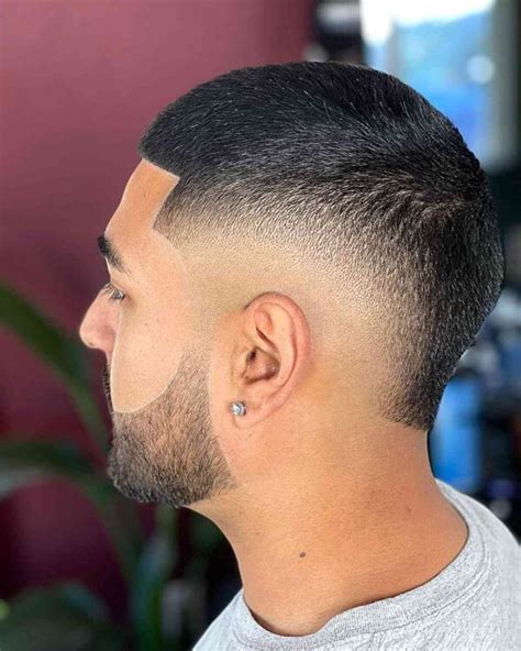 3. Trim the top and sides. Although this is recommended, there isn't really a "correct" place to start when trimming a buzz cut. Starting with the top and sides just seems like a logical way to ease into the trim, as the back can be a little bit trickier as you'll soon see.. 