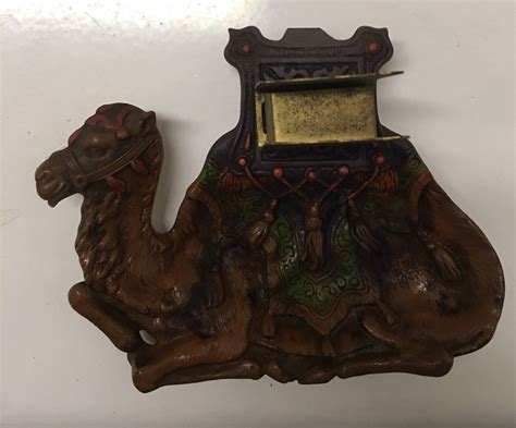 Joe Camel ashtray on stand. Ashtray and stand are metal. Unit folds for mailing and storage. Dimensions are 24 x 15 x 8. Unit weighs over 8 pounds. T is some rust around the bottom of the stand, not v. 