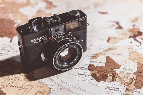 Camera company that merged with Konica crossword clue