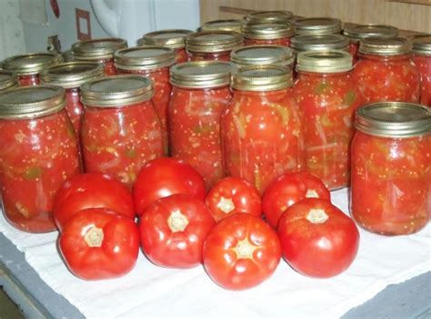 Canning stewed tomatoes. When all tomatoes are prepared, fill one jar at a time, keeping the other jars hot while you work. Add 2 tablespoons lemon juice and 1 teaspoon salt to each quart jar. Pack tomatoes into jars, pressing gently on tomatoes until the juice fills the spaces between tomatoes. Leave 1/2 inch headspace. Remove air bubbles. 
