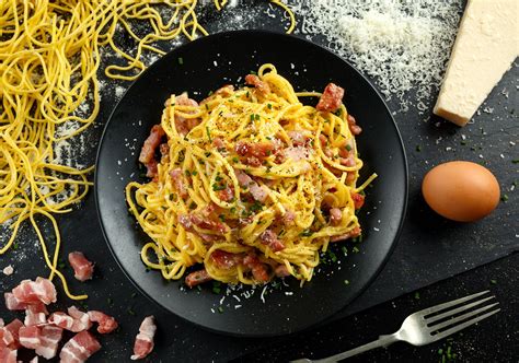 Carbonara restaurant. 2. Meanwhile, cook the spaghetti in plenty of boiling, salted water until al dente. In a bowl, beat together the eggs and the extra yolk and then stir in the the pecorino and most of the parmesan ... 