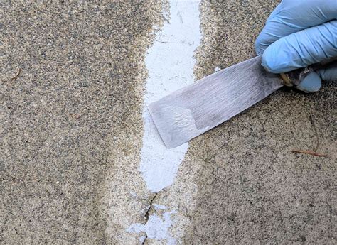 Cement crack repair. To sand down concrete, remove any coating, seal the cracks and joints with an epoxy filler, attach metal-bonded diamond discs to a grinder, and sand the surface of the concrete. St... 