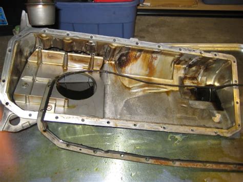 An oil pan is a metal container that contains the e