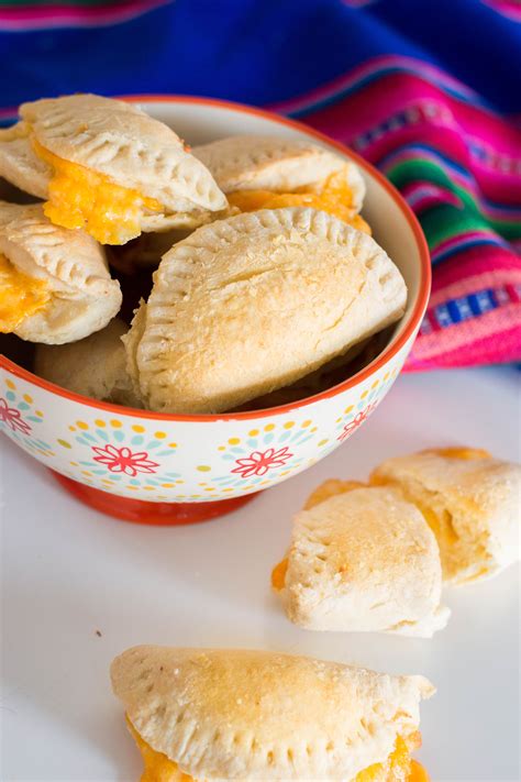 Cheese empanadas. Spoon a spoonful of cream cheese mixture in the center of the dough followed by a spoonful of raspberry mixture.. Fold the dough over in half and moisten the edges. Using a fork, crimp the edges to secure. Mix egg and water together in a small bowl and brush over each empanadas. Bake in preheated oven for 20-25 minutes. 