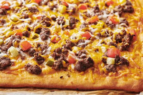 Cheeseburger pizza. Just remember to allow time for the rolls to rise. Cook the burger and bacon. Cook the bacon for 5 minutes, then add the beef and onions. Break the beef into small pieces. Once browned, drain any excess fat. Roll out the dough. Combine the thawed rolls and roll out into a 12″x18″ rectangle. 