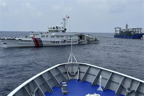 China’s forces shadow a Philippine navy ship near disputed shoal, sparking new exchange of warnings
