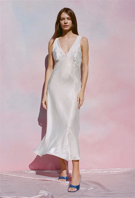 Ciao lucia. The Freja Dress in white is a midi-length dress featuring a square neckline, embroidery, and straps that tie in the back. Stretchy elastic at the back for an easy pull on style. Fit: True to Size. Model wears size small. Sizing: XXS-XXL Materials: 100% Cotton 