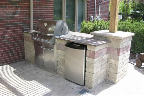 Cinder block outdoor kitchen. A concrete block or brick structure must be built on a solid, level slab of concrete. Concrete block and brick are affordable, weather and fire resistant, and easy to work with. Decorative concrete panels, stucco, tile and stone can all be used for the facing materials for your concrete block outdoor kitchen. 