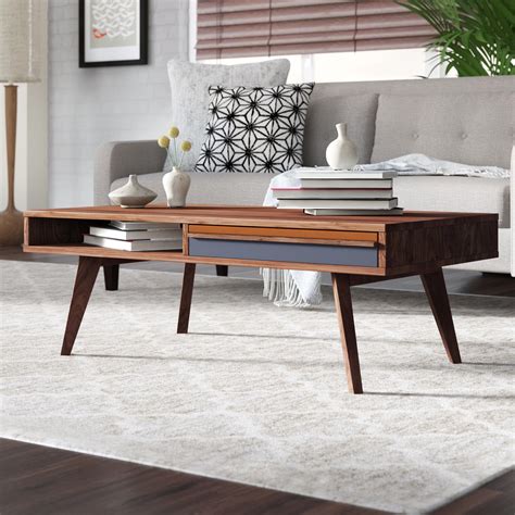Coffee table mid century modern. Uncluttered contrast. Built with solid wood and manufactured wood, this mid-century-inspired end table showcases clean lines + flared legs. Its airy silhouette is rounded out by a warm white tabletop, and an open lower shelf … 