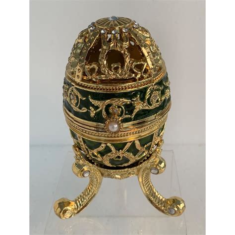 Collette et Cie music box collection.Beautiful pink, purple, blue, & green enamel flowers with rhinestones centers adorn this egg shaped music box.. Open the Egg to reveal the wonderful enamel and rhi. 