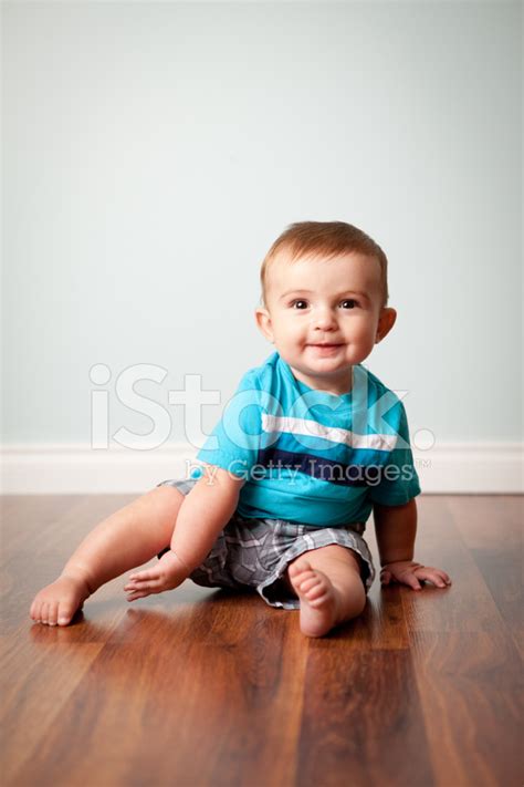 Color Photo Of Cute Baby Boy Sitting On Hardwood Floor Stock Photo …