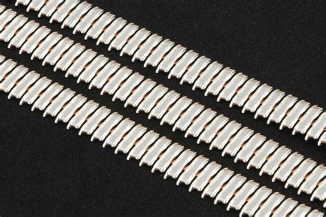 louvered contact band is a precision stamped metal strip. It is used for electrical power and signal transmission between the metal components of an electrical connection. The louver shaped contact bridges are arranged in parallel along the length of the metal band. Similar to ladder rungs they are attached to the side rims of the metal strip.. 
