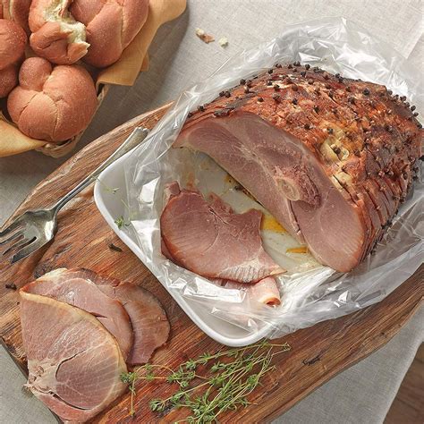 Preheat your oven to 325°F (165°C). Remove the shank ham from its packaging and place it on a roasting rack in a large baking dish. In a small bowl, mix together the brown sugar, Dijon mustard, and ground cloves to create a glaze. Brush the glaze evenly over the surface of the shank ham, ensuring that it is fully coated.