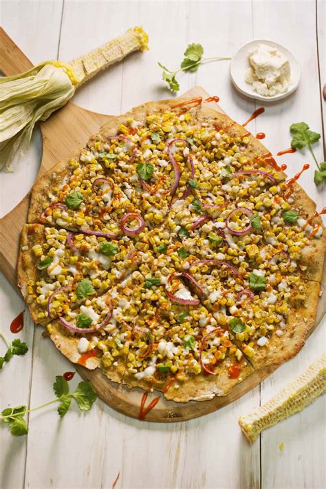 Corn pizza. Preheat a grill to medium-high heat. Place the pizza dough on the grill. Let cook for 1 minute, and then flip with tongs. Move to a cooler spot on the grill (about medium heat). 