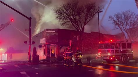 Crews battle raging fire at Lawrence liquor store